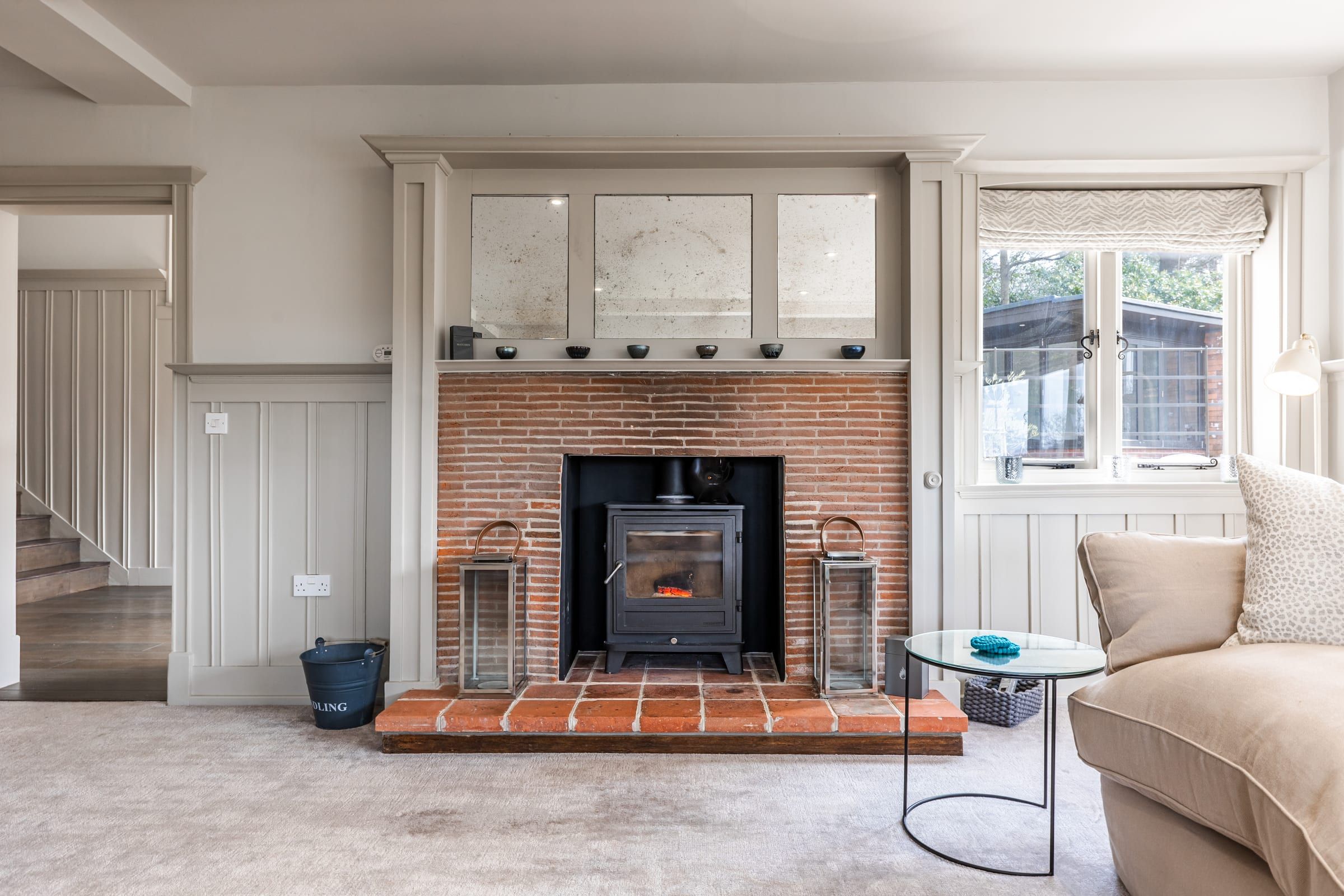 The drawing room fireplace with wood-burning stove at Orchid Lee